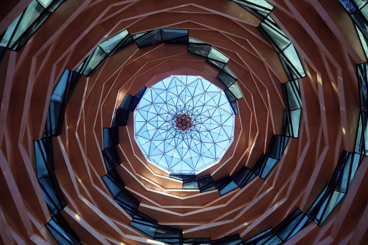 Abstract view of a modern spiral ceiling with glass and geometric patterns.