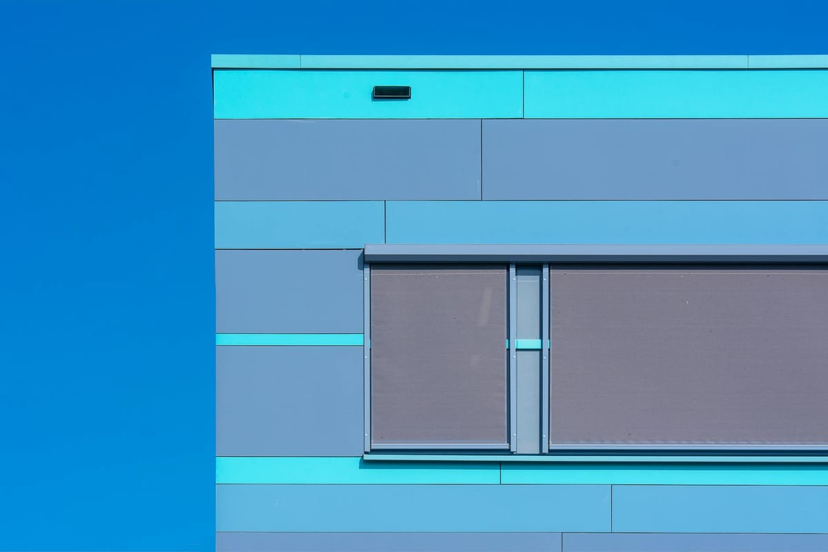 Minimalist photo of a modern blue building facade with geometric design.