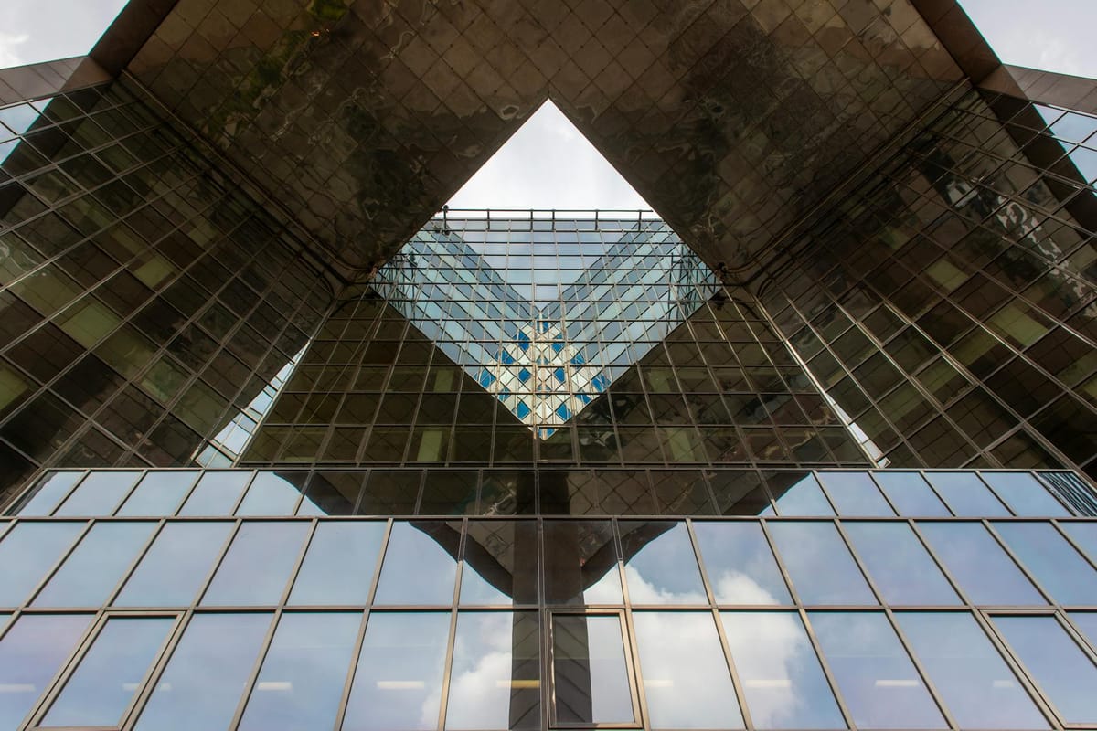 Symmetrical view of a modern building facade, showcasing glass reflections.