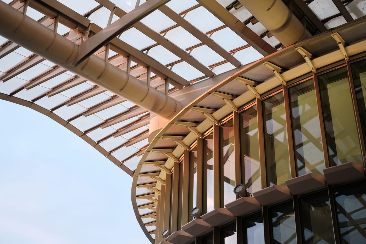 A low angle shot of a modern building showcasing glass and steel elements in elegant design.