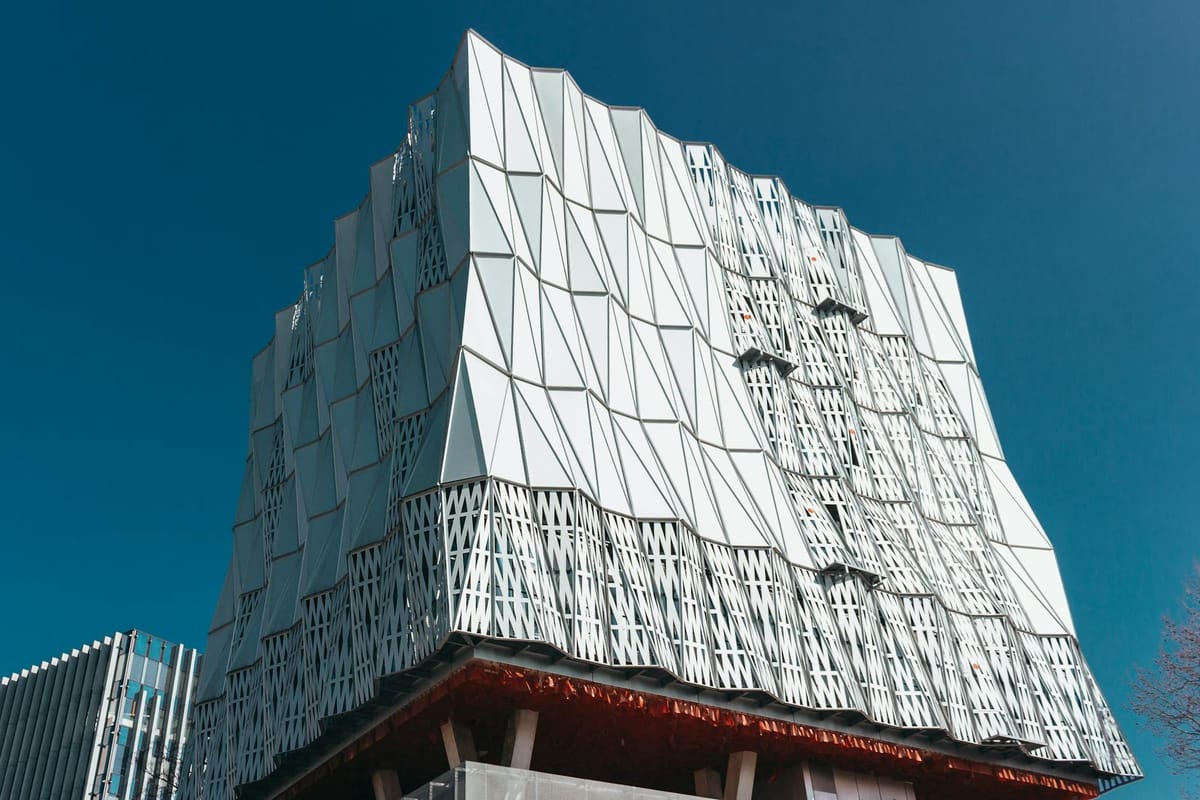 Stunning view of a contemporary building's facade with geometric patterns and clean lines under a clear blue sky.
